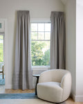 Coudre curtains in a living room with armchair