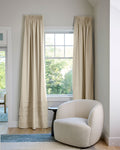 Coudre curtains in a living room with armchair
